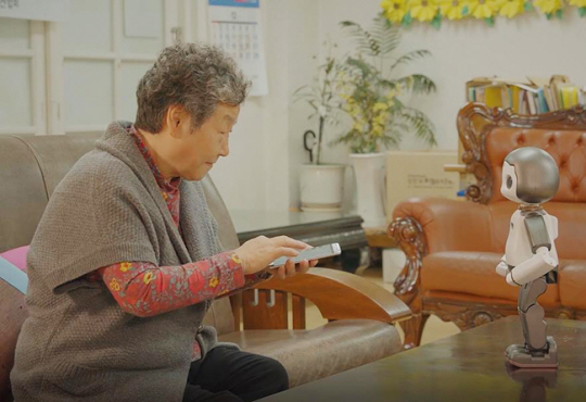 ▲ 서울 강남구에 거주하는 한 어르신이 로봇으로부터 스마트폰 활용 방법을 배우고 있다.