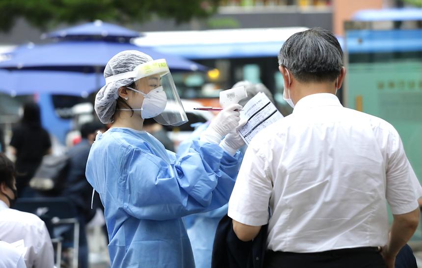 [르포-강남구 보건소] 선별진료소, 지금도 코로나19와 '사투중'    [바이러스로부터 대한민국을 지키는 사람들] 지칠 대로 지쳤다… 고비는 가을·겨울?    선별진료소에서 한 시민이 신종 코로나바이러스 감염증(코로나19) 검체 검사를 받고 있다./사진=뉴스1 박지혜 기자      “빨리 사라져야 할 텐데… 코로나가 내년엔 종식될 수 있을까요? 기약 없는 싸움에 보건소 의료진 모두 지쳤어요. 언제까지 (의료진이) 버틸 수 있을지….”  서울 강남구보건소에 설치된 선별진료소 앞에서 만난 임경수 강남구보건소 보건행정팀장의 말이다. 강남구보건소 직원은 신종 코로나바이러스 감염증(코로나19)의 재확산이란 불안감이 가시지 않아 긴장했고 지속된 무더위는 선별진료소 의료진을 지치게 만들었다.   지난 14일 0시부로 정부는 수도권 지역 사회적 거리두기 2.5단계를 2단계로 ‘조건부’ 완화했다. 2주간의 거리두기 노력으로 일일 신규 확진자가 점차 감소세를 보이면서 얻은 성과다. 그럼에도 여전히 세 자리를 유지하는 일일 신규 확진자수로 인해 방역 최일선에 있는 강남구보건소 의료진은 여전히 사투를 벌이고 있었다.        지난 15일 오후 1시30분. 강남구보건소에 들어서자마자 왼편에 마련된 선별진료소가 보였다. 의료진은 무더위로 지친 기색이 역력했다. 레벨D 방호복과 덧신·마스크 등 보호장구로 꽁꽁 동여맨 의료진은 땀에 젖은 얼굴을 손부채질로 겨우 식히고 있었다.   주민 2명이 코로나19 의심증상으로 선별진료소를 찾았다. 의료진은 지친 기색을 뒤로한 채 검사신청자를 안내했다. 주민 2명은 천막 안에 마련된 책상에 앉아 문진표를 작성했다. 문진표를 본 의료진은 진료를 시작했다. 다행히도 의료진은 주민 2명에게 진단검사가 필요 없다고 판단해 일반 병원으로 갈 것을 권유한 뒤 되돌려 보냈다.   검사신청자의 발길이 뜸해질 즈음 한 의료진은 더위를 식히기 위해 선풍기를 찾았다. 하지만 비닐로 된 방호복 재질 때문에 선풍기와 냉풍기의 찬바람을 제대로 느끼기 어려워 보였다. 선별진료소 의료진 A씨는 “가을인데도 유난히 덥다”며 “선풍기와 냉풍기라도 있어서 다행”이라고 말하며 미소를 지었다.     강남구청에 따르면 지난 15일까지 코로나19 의심증상으로 보건소를 찾은 시민은 5만4199명에 이른다. 전국에서 가장 많은 사람들이 진료를 본 단일 진료소다. 특히 유동인구가 많은 탓에 역학조사 건수도 전국에서 최대 수치다. 임 팀장은 “강남구 보건소 같은 경우 관내 주민만 선별해 검사하고 있지 않다”며 “강남이라는 지역 특성상 유동인구가 많다 보니 검사 인원도 늘었다”고 설명했다.  강남 구보건소 선별진료소는 코로나19 사태 이후 오전 8시반부터 오후 8시까지 6명씩 3개조로 운영되고 있었다. 주말에는 9시부터 7시까지 운영한다.    선별진료소 의료진 B씨는 “4시간마다 교대를 하고 있다”며 “이날(15일)은 160명의 시민이 코로나19 의심증상으로 진료를 봤다”고 말했다. 이어 “하루하루 진료 인원이 천차만별이다. 많을 때는 1000명 가까이 진료소를 찾는다”며 “전날(14일)에는 740명이 진료소를 방문했다”고 말했다.    임 팀장은 “선별진료소 의료진은 주말에도 일하기 때문에 거의 쉬지 못하고 있다”며 “대체휴무로 근무 인원을 배분하고 있지만 체력도 이미 한계”라고 우려했다. 이어 “이번 수도권 확산세로 검사 인원이 이전보다 3배 이상 늘었다”며 “다행히 해외 입국자에 대한 검사가 줄어 버틸 만 했다”고 덧붙였다.        수도권에서 잇따라 발생한 집단 감염 사태에 9개월 넘게 이어진 코로나19와 사투로 의료진의 피로도는 한계치를 넘어선 상태다. 강남구에선 끊임없이 추가 확진자가 나오고 있다. 9월16일 기준 강남구의 누적 확진자수는 240명에 이른다. 서울시의 26개 자치구 중 7위에 해당한다.  임 팀장은 “최대한 인력 배분을 고르고 적절하게 하려고 노력하지만 매일 다르게 발생하는 집단감염에 보건소 직원 모두 힘겨운 싸움을 이어가고 있다”며 “대부분 책임감으로 버틴다”고 성토했다.    문제는 가을과 겨울이다. 방역당국은 코로나19와 인플루엔자가 동시에 유행하는 ‘트윈데믹’ 가능성에 골머리를 앓고 있다. 코로나19와 독감은 발열·기침·근육통 등 초기 증상이 유사해 정확한 검사 없이는 구분하기 어렵다. 무엇보다 두 질병에 동시에 감염되는 사례도 발생할 수 있어 선별진료소에서의 혼선이 불가피할 것으로 보인다.   임 팀장은 “가을과 겨울 진료소 내 혼선은 불가피할 것으로 예상된다”면서도 “국민이 방역을 잘 지켜준다면 고비를 무사히 넘어설 수 있을 것으로 생각한다”고 희망을 피력했다. 