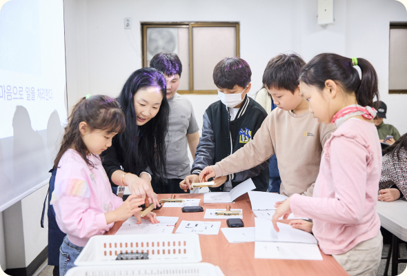 전통 제본 방식으로 책 만드는 체험을 하는 아이들