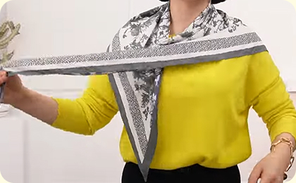 1.삼각형으로 접은 스카프를 어깨에 두르고, 오른쪽은 짧게 왼쪽은 길게 길이를 조정한다.