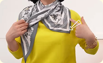 2.스카프 후면의 뾰족한 꼭지점 부분의 위치를 어깨 사선 아래로 맞춘다.