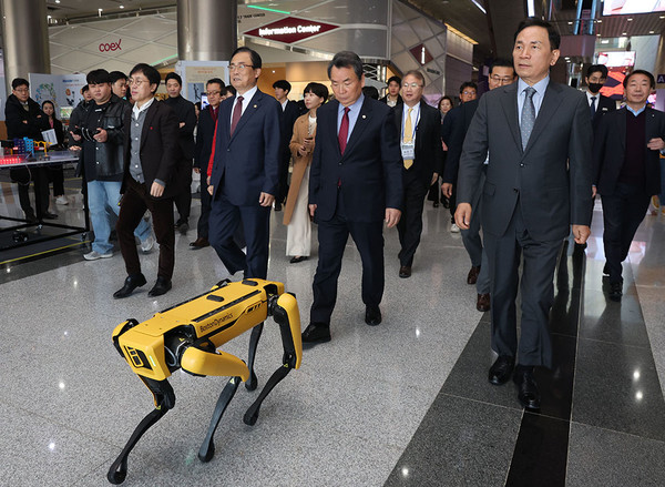 강남 로봇 페스티벌 현장에서 로봇 개의 안내를 받아 이동하는 조성명 강남구청장(맨 앞 오른쪽) [강남구 제공]